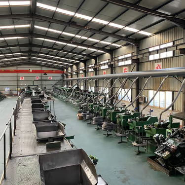 Rows of screw-production machinery in a workshop